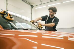 Auto Mechaniker im ein Werkstatt Ändern Auto Fenster foto