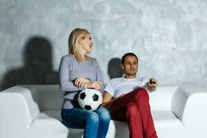 fasziniert Mann und Frau Aufpassen Fußball Spiel foto
