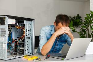 Computer Ingenieur Arbeiten auf gebrochen Konsole im seine Büro foto