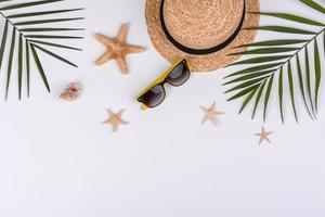 Strandaccessoires, Brille und Hut mit Muscheln und Seesternen auf farbigem Hintergrund foto