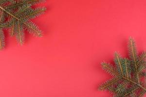 rote Weihnachtsdekorationen, Tannenzweige auf rotem Hintergrund