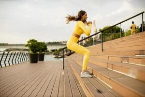 junge Frau springt auf die Treppe am Flussufer foto