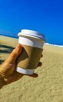 Kaffee zu gehen Becher auf das Strand Sand Meer Wellen. foto