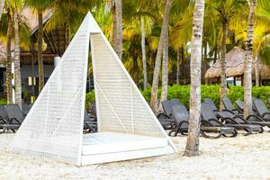 Palapa mit Stroh gedeckt Dächer Palmen Sonnenschirme Sonne Liegen Strand Resort Mexiko. foto