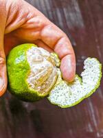 Hände schälen ein Grün Orange Zitrusfrüchte Obst im Mexiko. foto