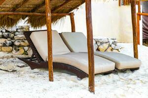 Palapa mit Stroh gedeckt Dächer Palmen Sonnenschirme Sonne Liegen Strand Resort Mexiko. foto