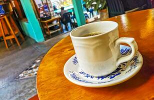 blauer weißer tassentopf mit schwarzem kaffeeholztisch mexiko. foto