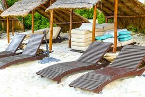 Palapa mit Stroh gedeckt Dächer Palmen Sonnenschirme Sonne Liegen Strand Resort Mexiko. foto