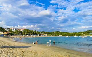 Palmen Sonnenschirme Sonne Liegen Strand Menschen Zikatela puerto escondido Mexiko. foto