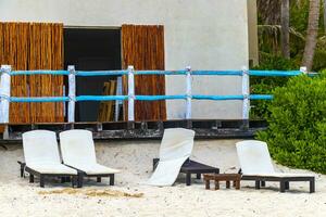 Palapa mit Stroh gedeckt Dächer Palmen Sonnenschirme Sonne Liegen Strand Resort Mexiko. foto