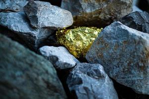 Goldnugget und grauer Granitsteinhintergrund foto