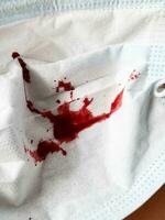 ein Nahansicht Schuss von ein rot Blut auf ein Weiß Maske Hintergrund foto