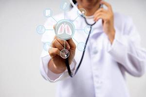 Digitales Bildschirmsymbol und Arzt in Uniform verwenden Stethoskop, um die Lunge zu überprüfen