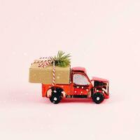 rot Spielzeug Auto liefern Weihnachten oder Neu Jahr Geschenk Geschenk Box auf Rosa Hintergrund. foto
