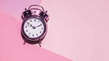 Draufsicht Uhr rosa Hintergrund. hochwertiges schönes Fotokonzept foto