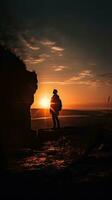 Silhouette von ein Person bewundern das Sonnenuntergang beim das Kante von ein Cliff foto