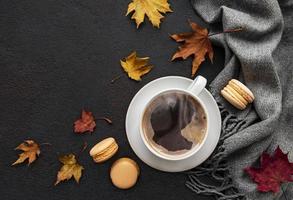 Tasse Kaffee und trockene Blätter auf schwarzem Betonhintergrund foto