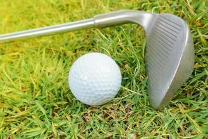 Golfschläger und Golfball auf grünem Grashintergrund foto