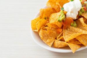 mexikanische Nachos-Tortilla-Chips mit Jalapeno, Guacamole, Tomatensalsa und Dip foto