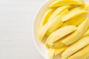 frische grüne und goldene Mango auf Teller geschnitten on
