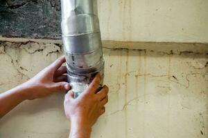 Nahansicht Hände von Arbeiter halten Werkzeuge und verzinkt Rohr zu Reparatur beim Konstruktion Seite? ˅ foto