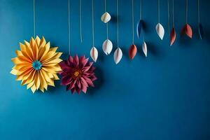 drei bunt Papier Blumen hängend von Saiten auf ein Blau Mauer. KI-generiert foto