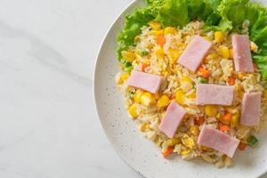 hausgemachter gebratener Reis mit Schinken und gemischtem Gemüse aus Karotten, grünen Bohnen und Mais foto