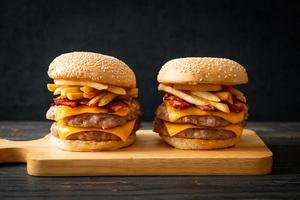 Schweinefleisch-Hamburger oder Schweinefleisch-Burger mit Käse, Speck und Pommes frites foto