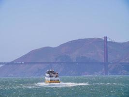 Sonniger Blick auf ein Kreuzfahrtschiff und die Golden Gate Bridge foto
