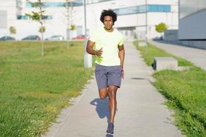 schwarzer athletischer Mann, der in einem Stadtpark läuft. foto