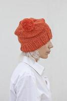 hübsche junge Frau in warmer orangefarbener Mütze