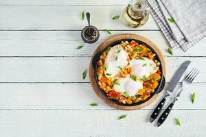 Shakshouka im braten Pfanne. gebraten Eier mit Gemüse, Tomate, Pfeffer, Kürbis und Zwiebel. oben Aussicht foto