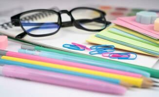 Lehrer Tag. Brille und Schule Schreibwaren auf das Tisch. zurück zu Schule. Nahansicht. selektiv Fokus. foto