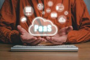 paas - - Plattform wie ein Service, Mann Hand halten paas Symbol auf vr Bildschirm auf Schreibtisch Hintergrund, Internet Technologie und Entwicklung Konzept. foto