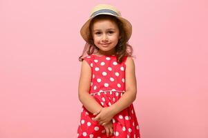 wenig Kind Kind Baby Mädchen 3-4 Jahre alt tragen Rosa Polka Punkte Kleid und Sommer- Hut , isoliert auf Rosa Hintergrund, Kinder Studio Porträt. Mutter Tag, Liebe Familie, Elternschaft Kindheit Konzept foto