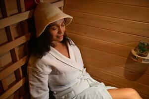 schön gemischt Rennen Frau ruhen im Infrarot Sauna. Nahansicht. Spa Behandlung, Alternative Schönheit Therapie. foto