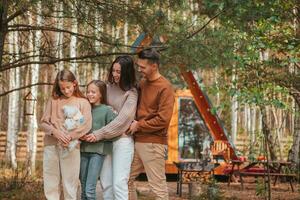 Familie mit zwei Kinder beim Herbst warm Tag mit ihr Weiß Hündchen foto