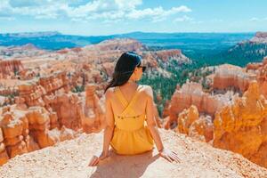 Wanderer Frau im Bryce Schlucht ruhen genießen Aussicht im schön Natur Landschaft mit Hoodoos, Zinnen und Türme Felsen Formationen im Utah foto