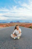 szenisch Autobahn im Monument Senke Stammes- Park im Utah. glücklich Mädchen auf berühmt Straße im Monument Senke im Utah. foto