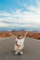 szenisch Autobahn im Monument Senke Stammes- Park im Utah. glücklich Mädchen auf berühmt Straße im Monument Senke im Utah. foto