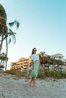 glückliche frau, die schönen sonnenuntergang am strand genießt foto