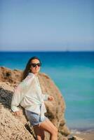 junge glückliche Frau am Strand genießt ihren Sommerurlaub foto