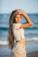 bezaubernd jung Mädchen mit schön lange Haar genießen tropisch Strand Urlaub. das Mädchen auf das Strand beim Sonnenuntergang foto