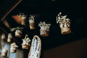 origineller Hochzeitsblumenschmuck in Form von Minivasen und Blumensträußen, die von der Decke hängen foto