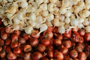 Zwiebel und Knoblauch auf Anzeige beim lokal Markt, Nahansicht von frisch rot Zwiebeln und Knoblauch, foto