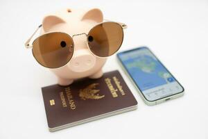Speichern zum Ferien und Budget Konzept. Smartphone, Reisepass, Schweinchen Bank tragen Sonnenbrille zum Ferien Reise. vorbereiten zum Urlaub. foto