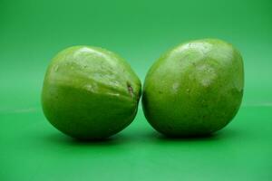 2 Avocados platziert im das Mitte von ein Grün Hintergrund. foto