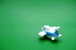 Mini Flugzeug Spielzeug isoliert Grün Hintergrund. Weiß und Blau Flugzeug Spielzeug. foto