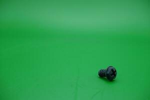 ein Spielzeug Schraube auf ein Grün Hintergrund foto