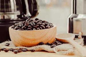 Kaffeebohne auf Holzschale mit hausgemachtem Kaffeehintergrund foto